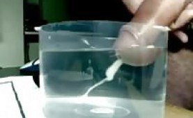 Guy shoots his jizz in a cup of water
